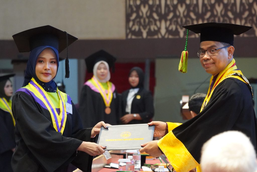 Rektor saat menyerahkan ijazah wisudawan pada Wisuda ke-144 hari pertama, Senin (24/8/2028). (Foto: Dian Melsa/ Kantor Komunikasi dan Pemasaran Strategis)