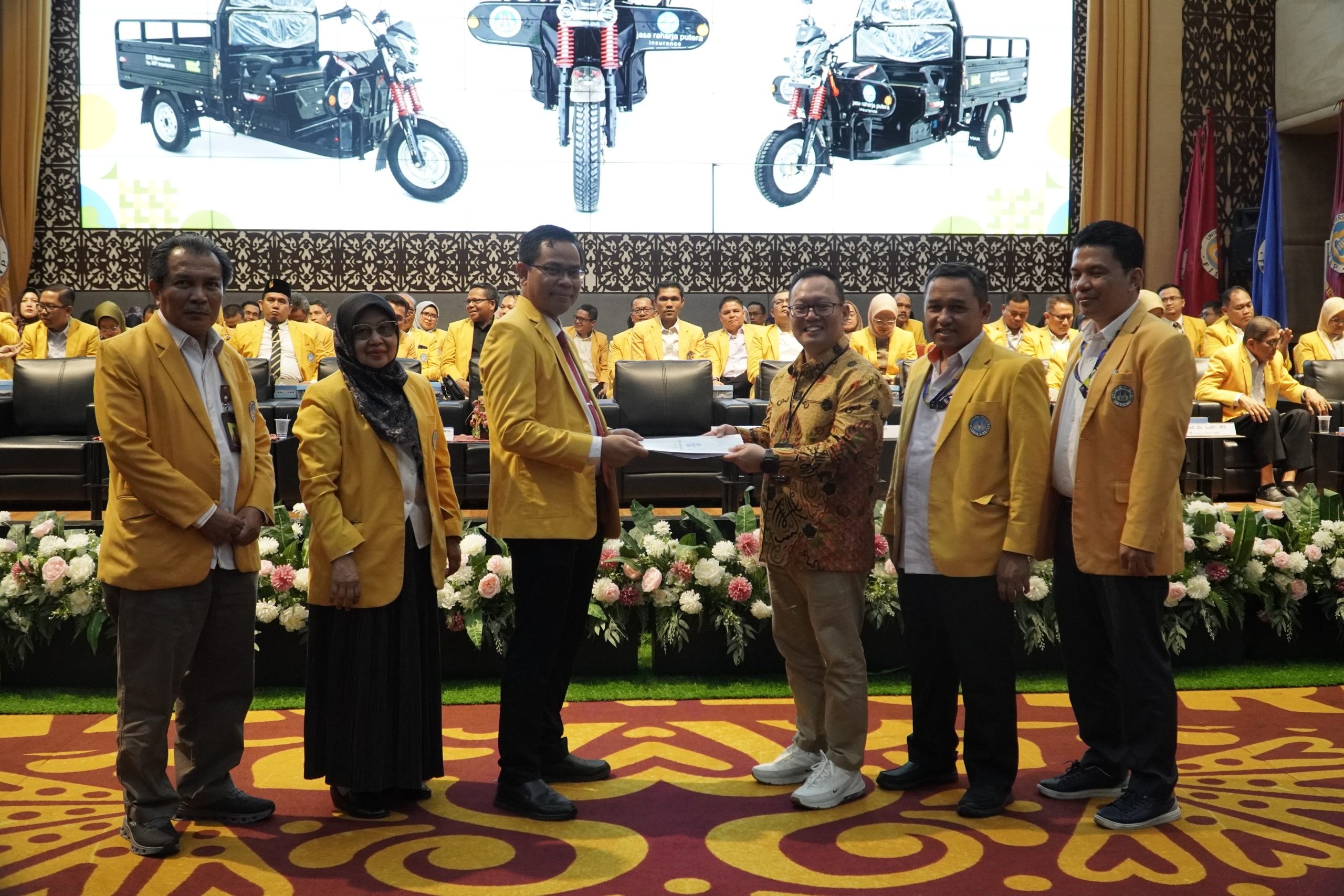 Rektor (ketiga kiri) menerima kunci motor listrik dari Branch Manager Jasa Raharja Putera Padang, Fitri Suryasi, S.Sos., AAAIK, ICBU. (Ketiga kanan) secara simbolis (Foto: Dian Melsa/Kantor Komunikasi dan Pemasaran Strategis)