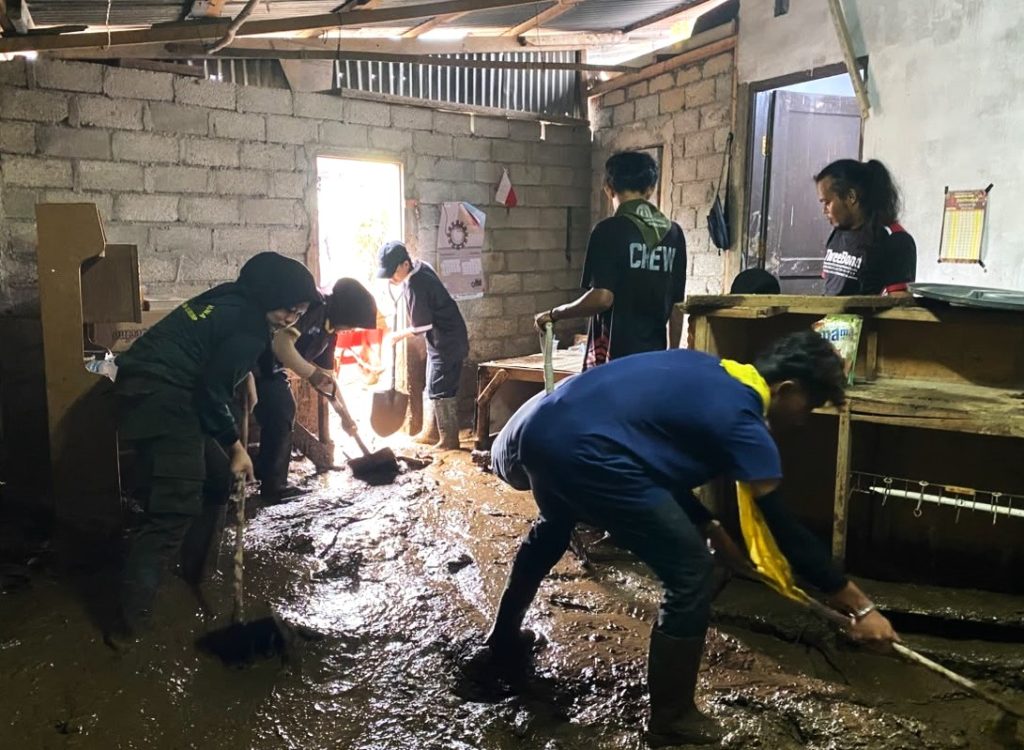 Tim Satgas Peduli Bencana Alam UNP saat membantu membersihkan rumah warga terdampak bencana banjir bandang di Kabupaten Solok.