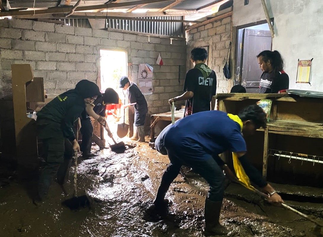 Tim Satgas Peduli Bencana Alam UNP saat membantu membersihkan rumah warga terdampak bencana banjir bandang di Kabupaten Solok.