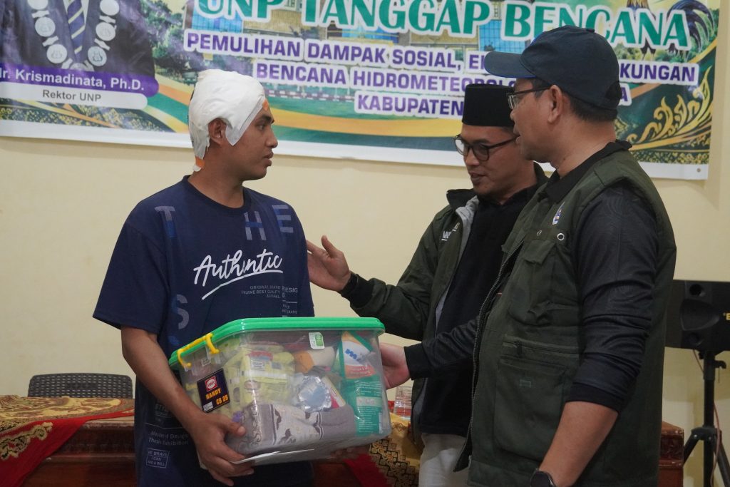 Rektor (kanan) saat menyerahkan bantuan kepada salah satu korban bencana di Solok. (Foto: Tim KKPS)